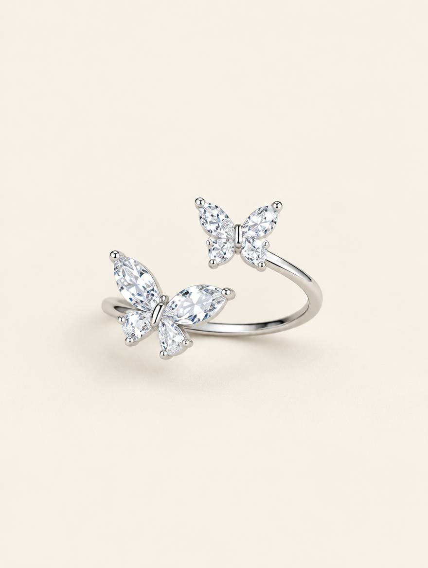 Silver twin butterfly sparkling open ring on a neutral background