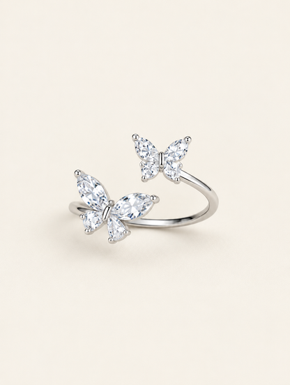 Silver twin butterfly sparkling open ring on a neutral background