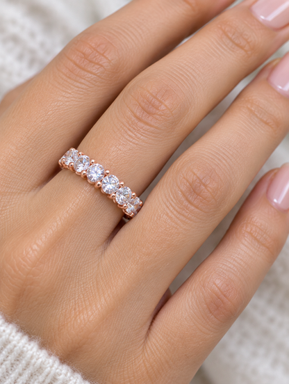 Woman wearing a rose gold zirconia eternity band ring on her finger